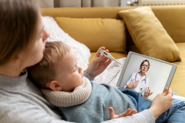 A mother holding her child during an online video consultation with an Irish doctor