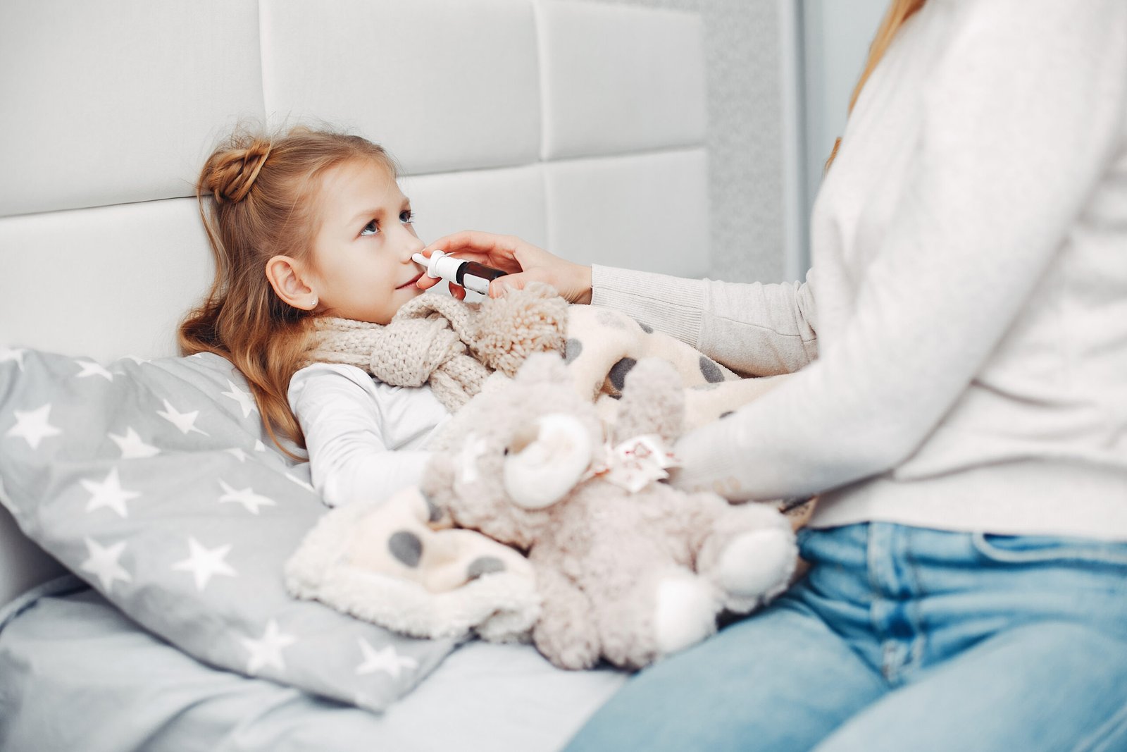 Mother comforting her ill daughter in bedroom