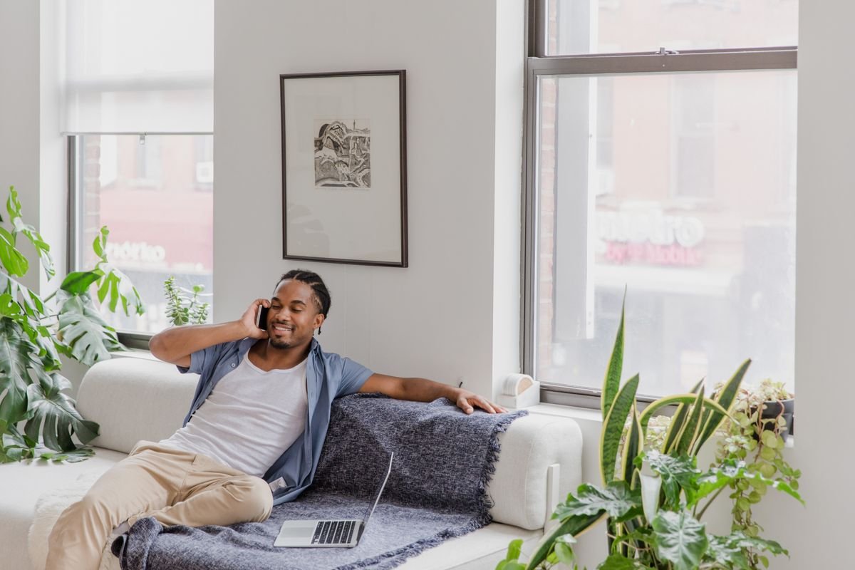 Man talking on the phone comfortably at home — private consultations from your own sofa