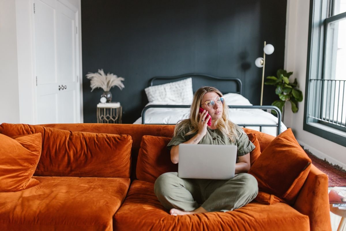 Woman at home on a phone and laptop consultation