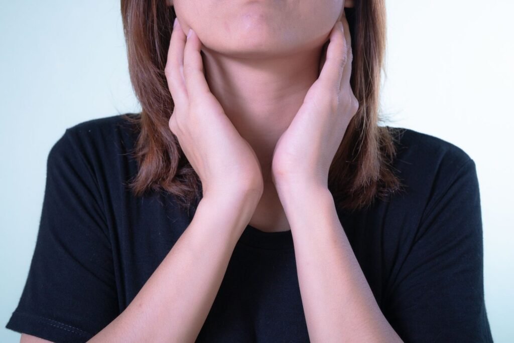 Person holding their sore throat